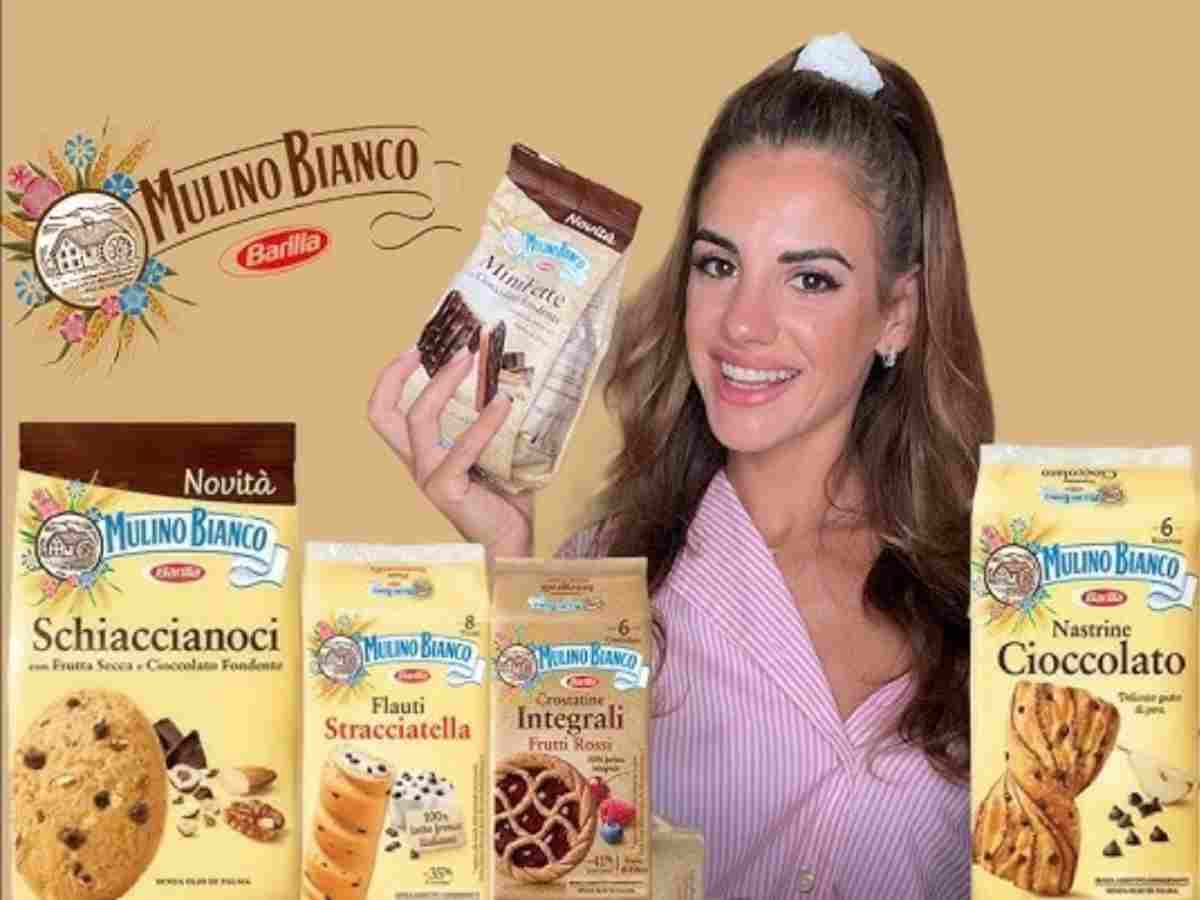 Una ragazza mostra i biscotti e le merendine del Mulino Bianco