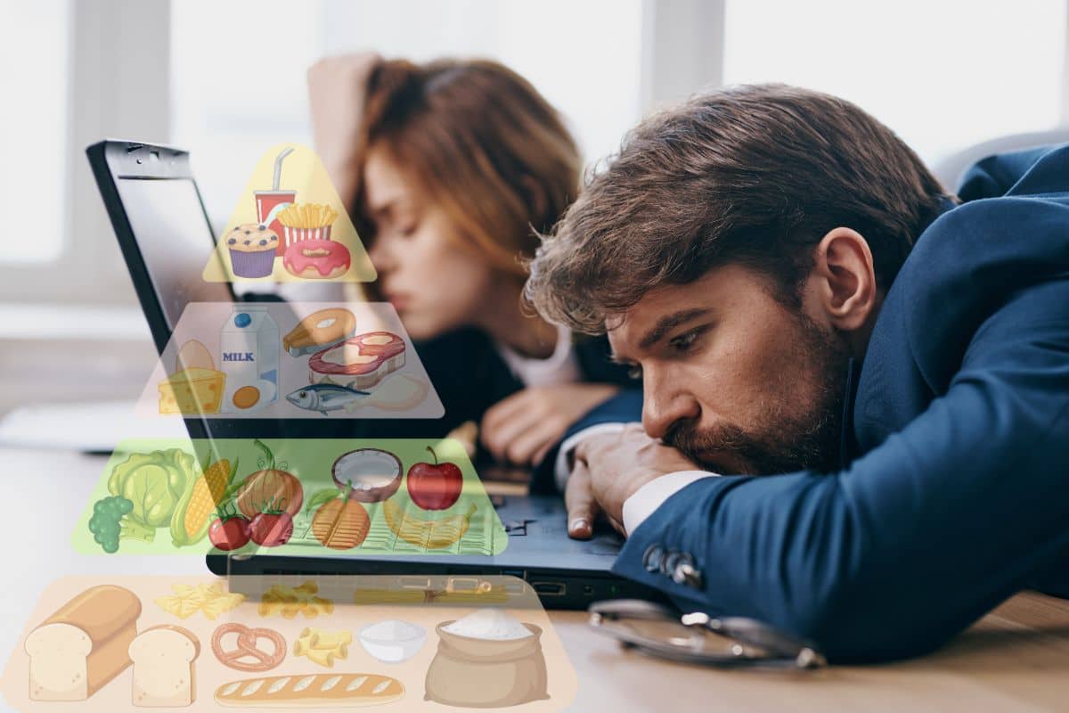 un uomo e una donna a lavoro davanti al pc stanchi con piramide alimentare