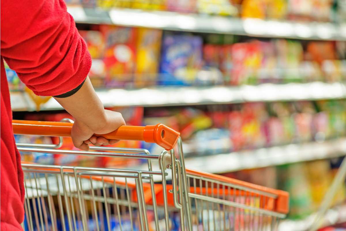 Persona spinge il carrello al supermercato