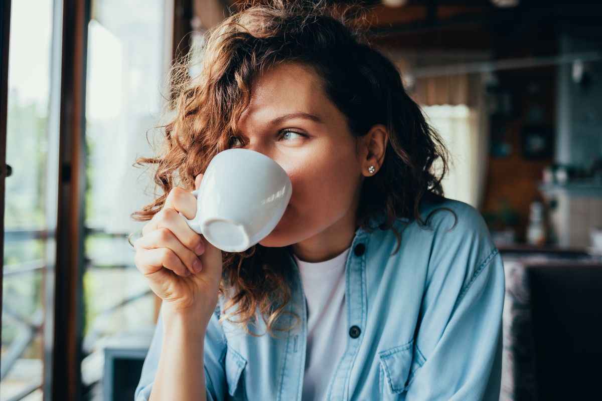 Ragazza beve tazza di caffè