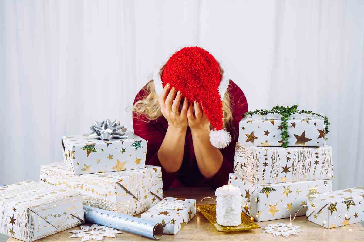 Ragazza depressa mentre confeziona i regali di Natale