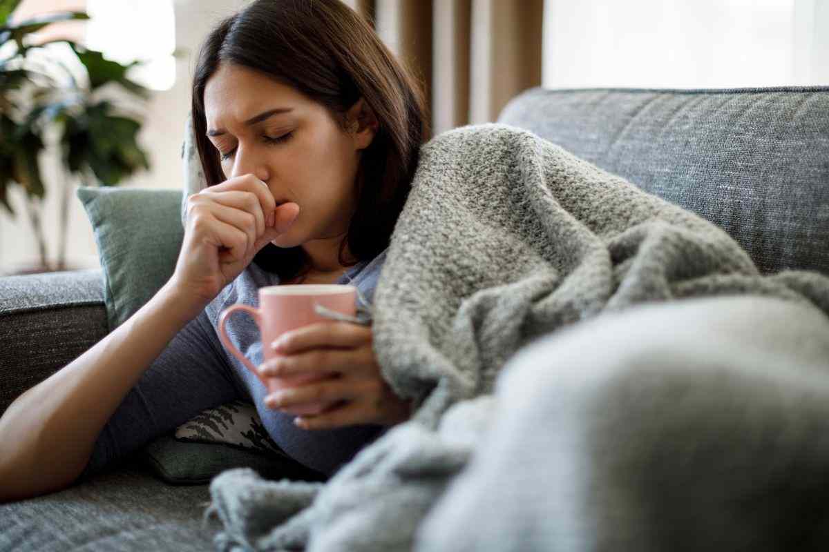 Ragazza influenzata beve tisana calda