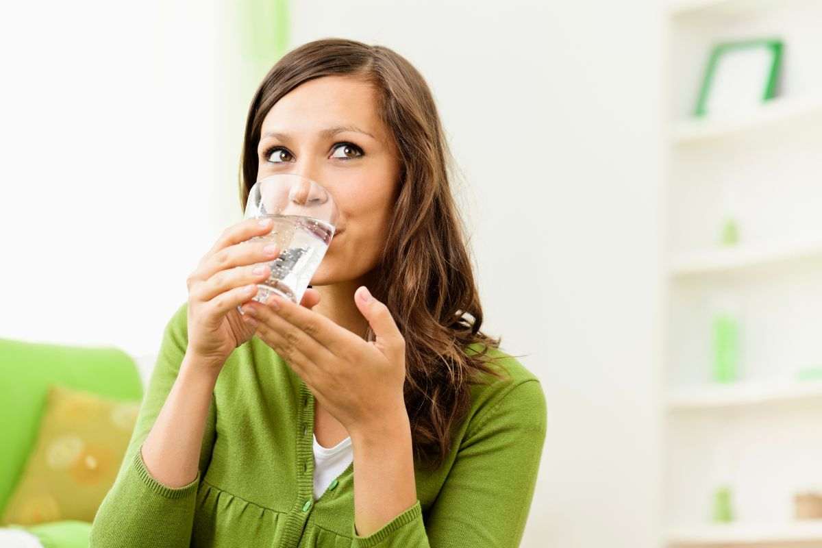 Ragazza beve bicchiere di acqua